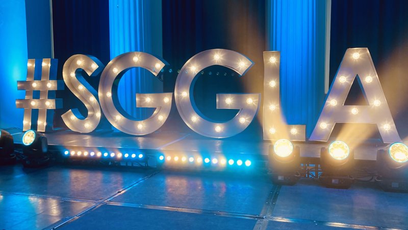 Large letters #SGGLA with lights on a stage with blue background