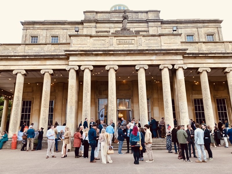 People standing at the front of a regency building with drinks