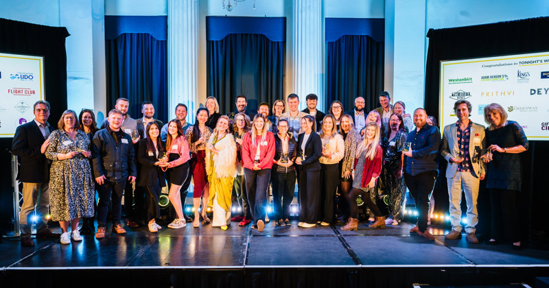 Group of winners with their awards on stage